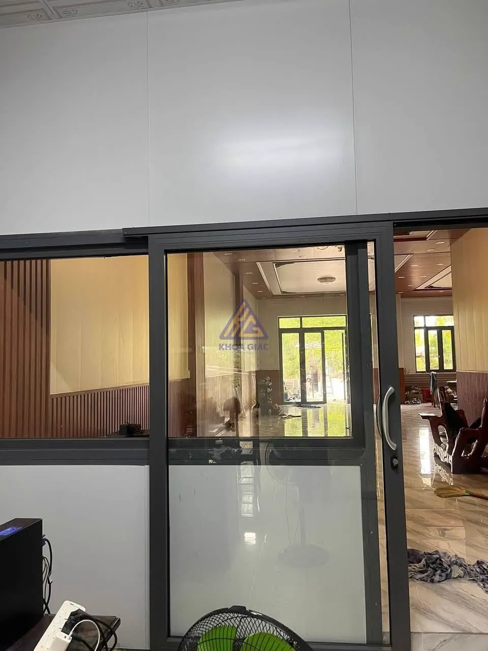 Cửa lùa treo 1 cánh khung nhôm đen, kính mờ nửa dưới, ngăn phòng làm việc