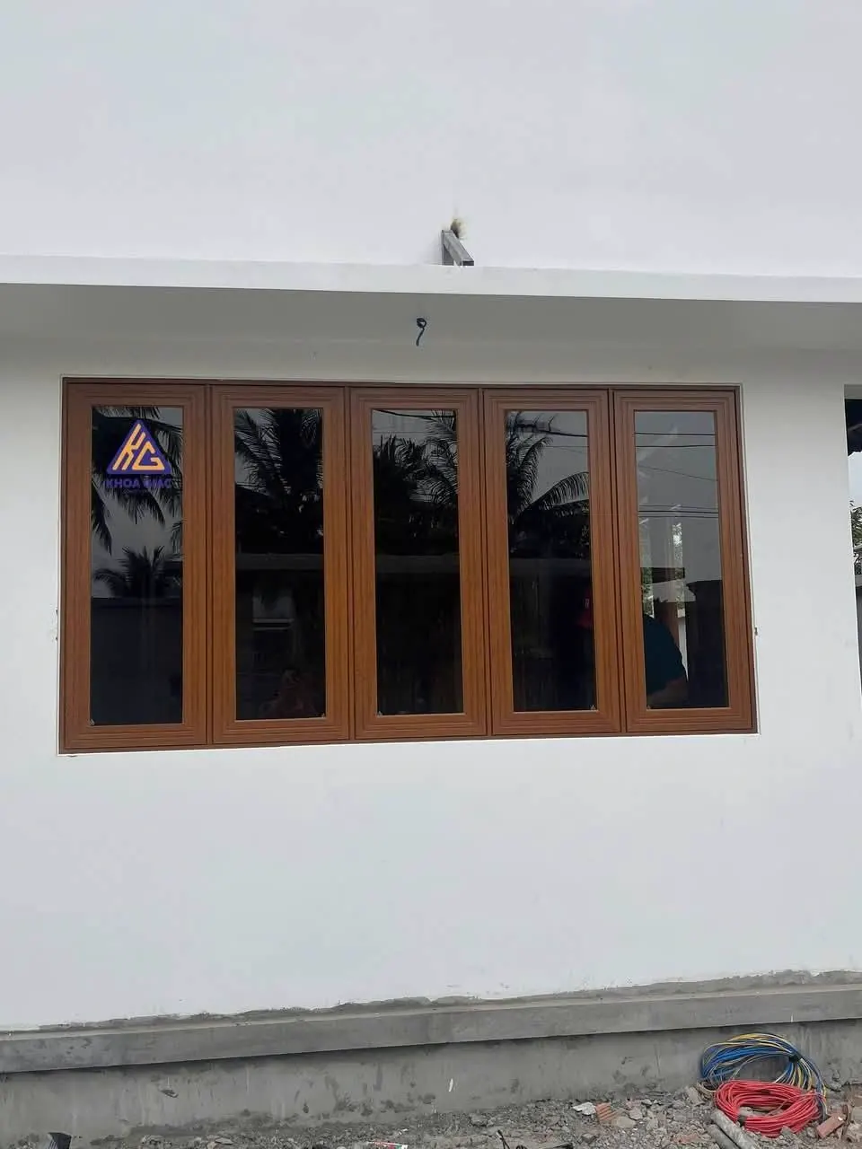 Cửa sổ nhôm vân gỗ nhiều cánh trên tường nhà cấp 4