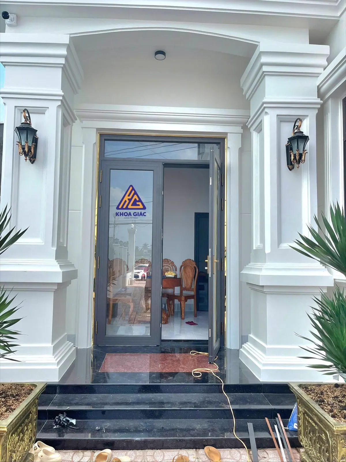 Cửa nhôm kính khung ghi ở sảnh vào nhà biệt thự tân cổ điển