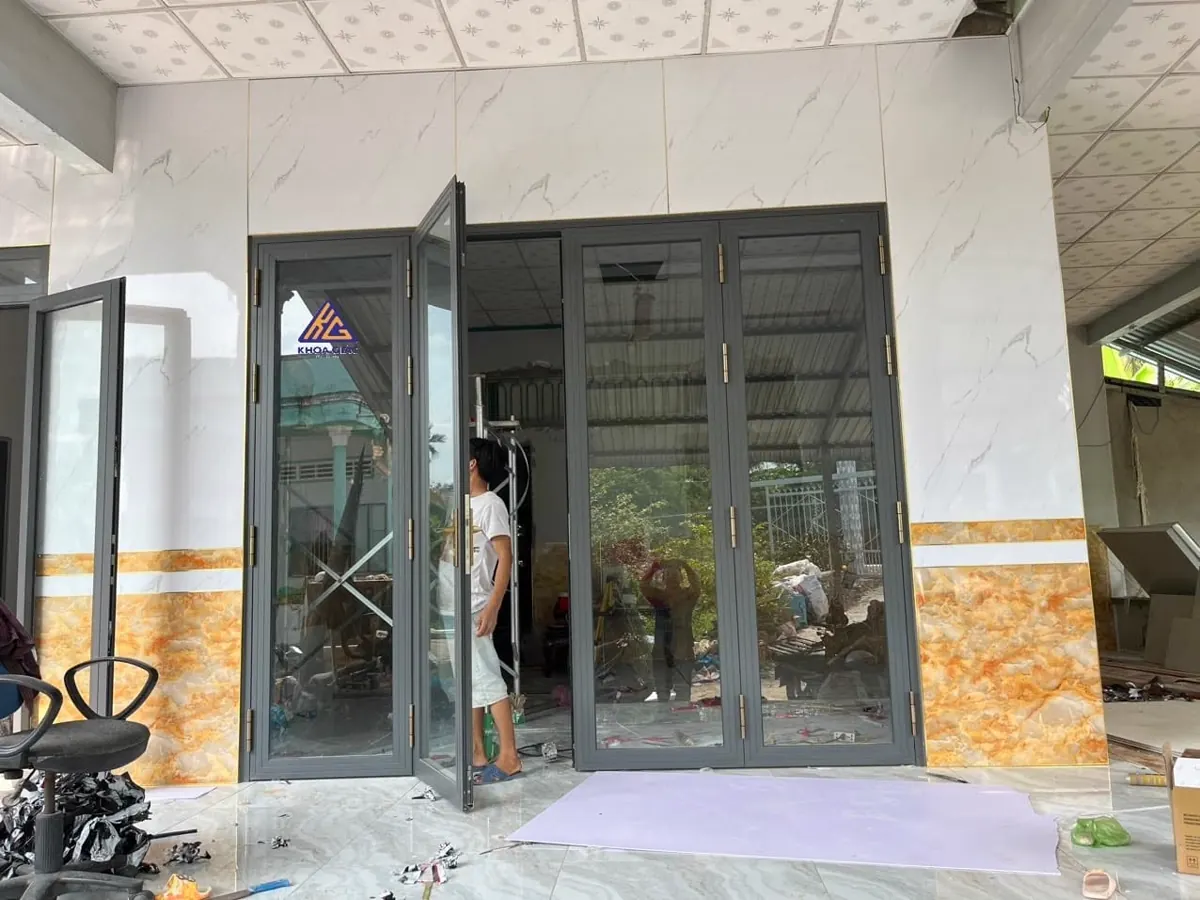 Cửa nhôm 4 cánh mở quay màu ghi, một cánh đang mở