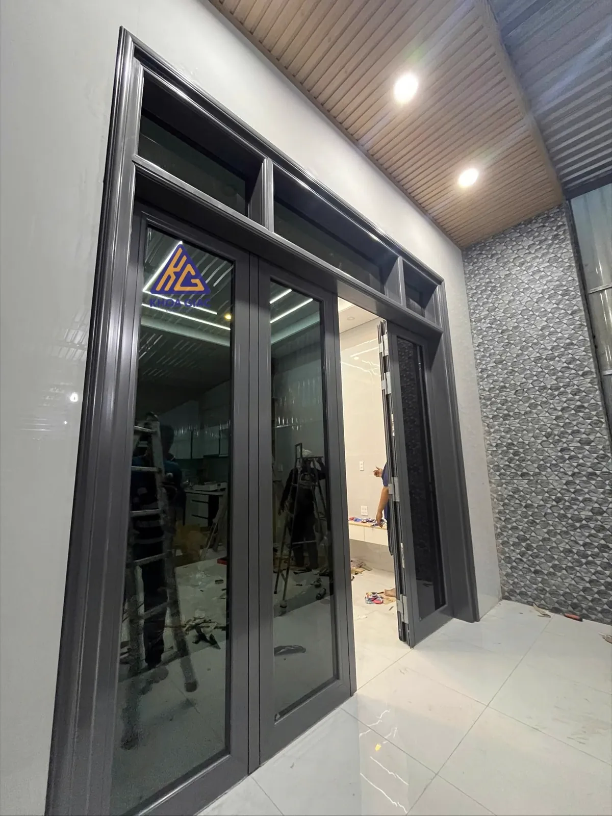 Cửa nhôm 4 cánh màu ghi đậm có vách kính phía trên cho nhà cấp 4